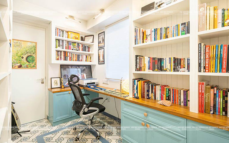 a home office with blue cabinets and a desk