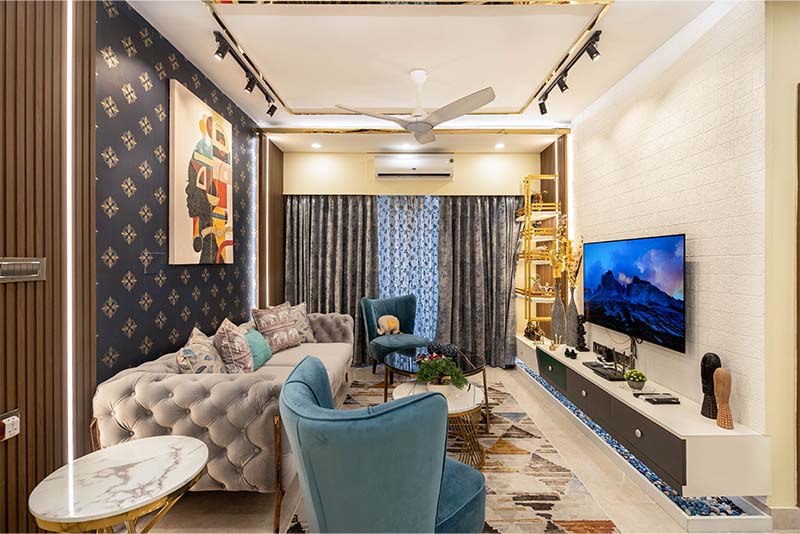 A stylish living room featuring blue chairs and a flat screen TV.