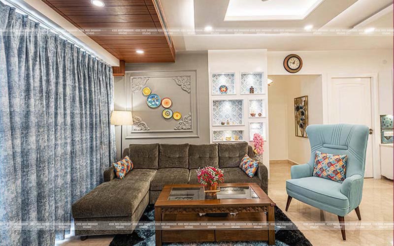 a living room with blue furniture and a coffee table and wall art