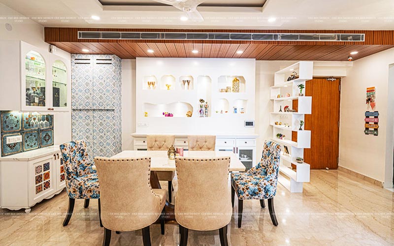 A dining room with a white table and blue chairs, creating a stylish and inviting atmosphere.