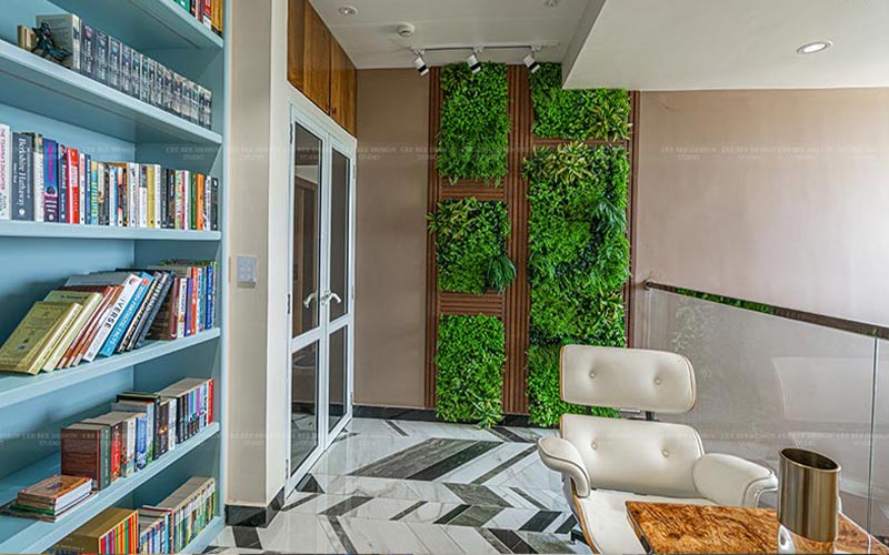 A cozy living room with bookshelves against a green wall, creating a serene and vibrant atmosphere.
