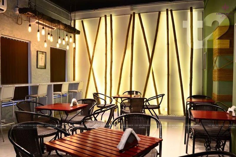 indoor dining area with wooden tables and chairs against a brick wall