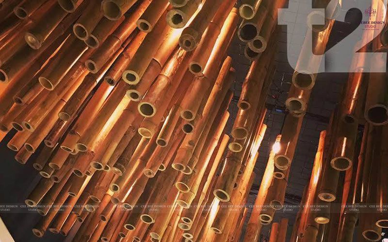 numerous copper pipes suspended from the ceiling in a spacious room