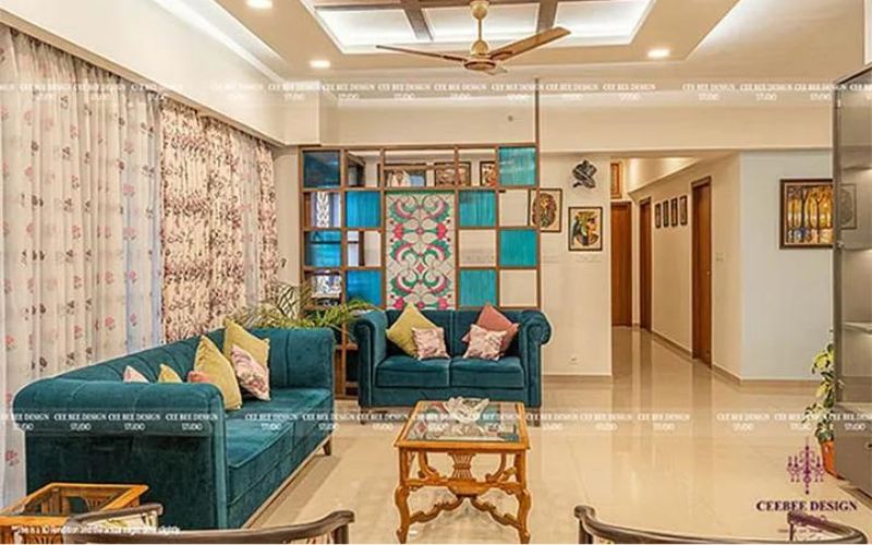 interior design living space with greenish blue velvet sofa and cushions with table and fan in the ceiling with side wall design and wall art