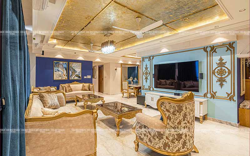 A living room with gold furniture and blue walls.