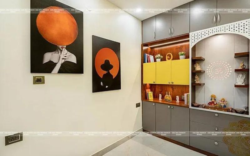 A modern home with a vibrant wall and a cabinet includes a puja room.
