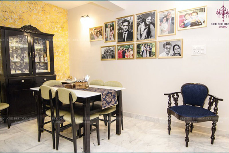 A tastefully decorated dining room with framed pictures adorning the walls and a well-set table.