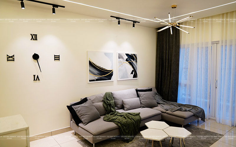 A contemporary living room featuring a couch, a clock, and a lamp, creating a stylish and cozy ambiance.