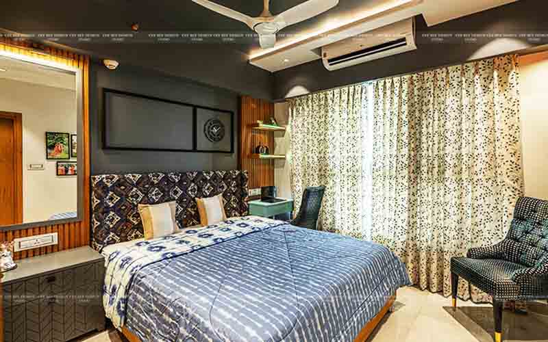 Interior of a bedroom with bed, chair, and fan.