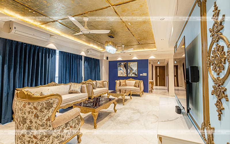 Luxurious living room with gold and blue decor, showcasing elegant turnkey interior design.